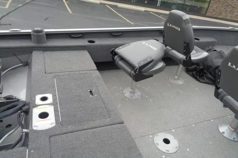 Slide: The Image of 2022 Lund 1775 Adventure SS boat interior with gray seating and storage compartments. - 10