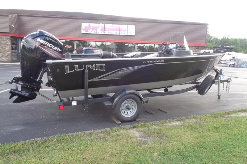 Slide: The Image of 2022 Lund 1775 Adventure SS boat on trailer, parked outside a store. - 28