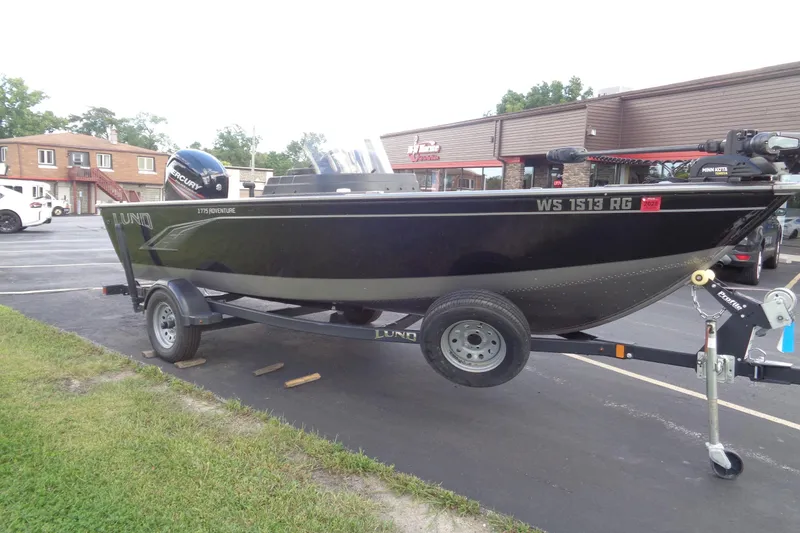 Slide: The Image of 2022 Lund 1775 Adventure SS boat on trailer, parked outside a building. - 29