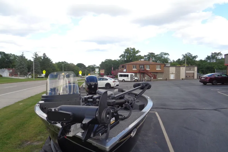 Slide: The Image of 2022 Lund 1775 Adventure SS boat parked in a suburban area with cars and buildings. - 31