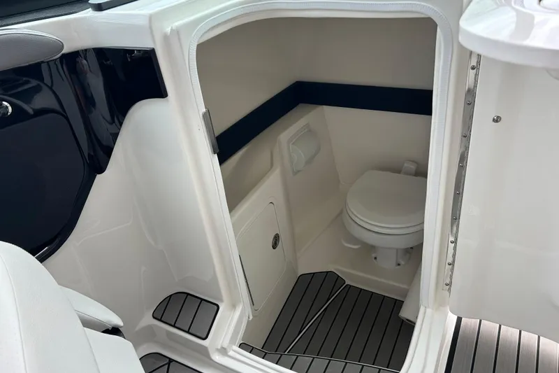 Slide: The Image of 2023 Sea Ray SLX 260 boat interior with compact bathroom and toilet. - 16