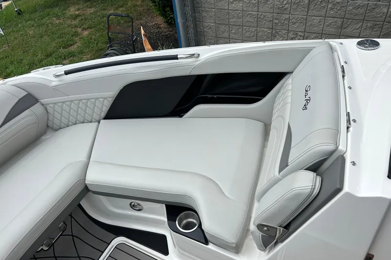 Slide: The Image of 2023 Sea Ray SLX 260 boat interior with luxurious white seating and cup holder. - 19