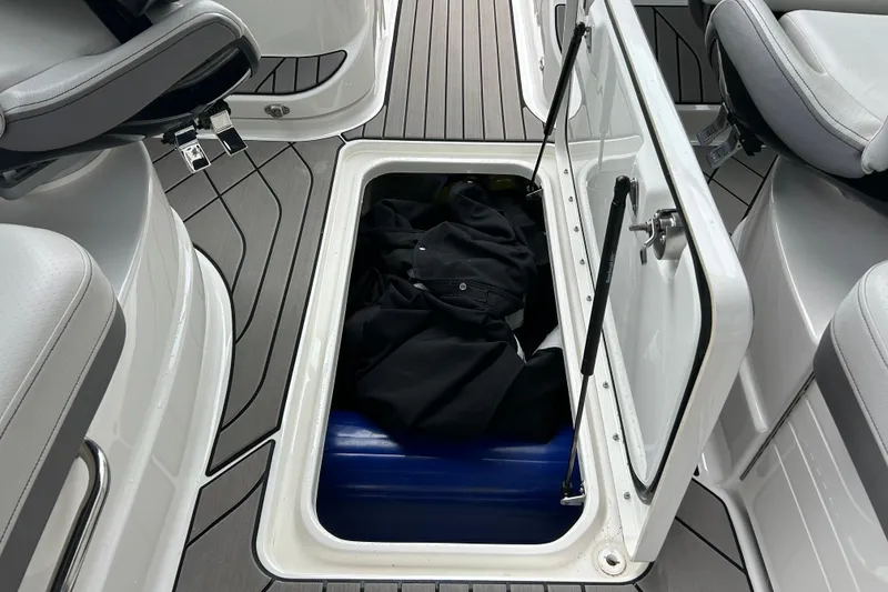 Slide: The Image of 2023 Sea Ray SLX 260 boat storage compartment with open hatch and interior view. - 23