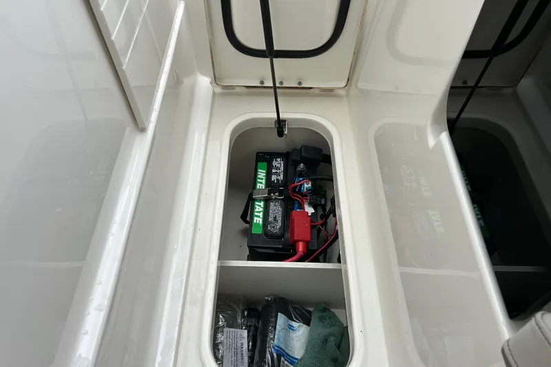 Slide: The Image of 2023 Sea Ray SLX 260 boat battery compartment with Interstate battery and storage space. - 26