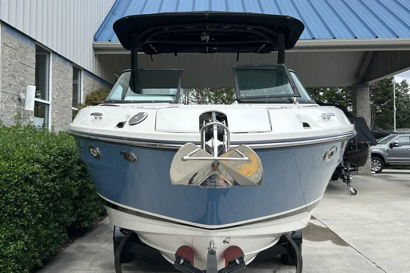 Slide: The Image of 2023 Sea Ray SLX 260 boat with blue hull, parked outdoors under a blue roof. - 3