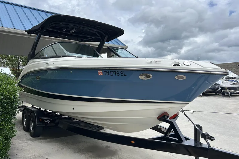 Slide: The Image of 2023 Sea Ray SLX 260 boat on trailer, blue and white design, parked outdoors. - 4