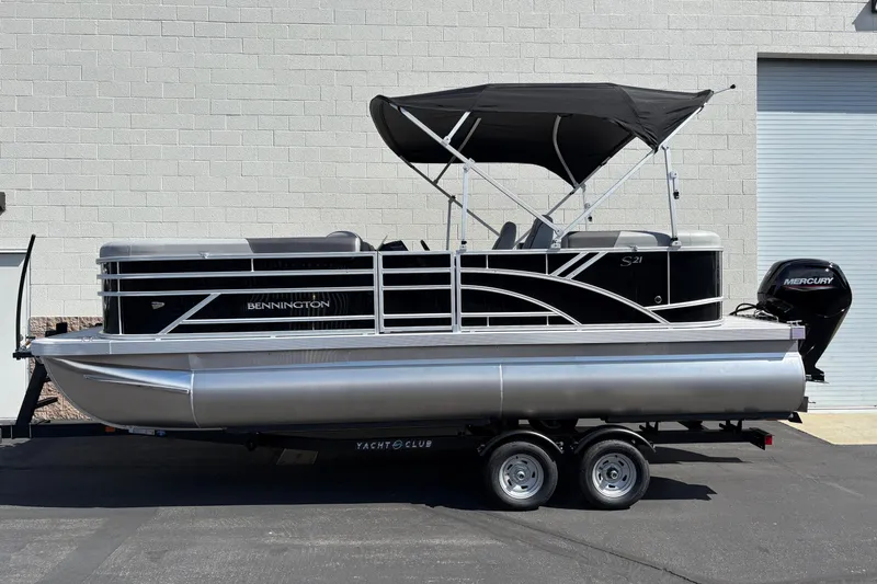 The Image of 2026 Bennington 21 SSR pontoon boat with black canopy and Mercury outboard motor. - 0
