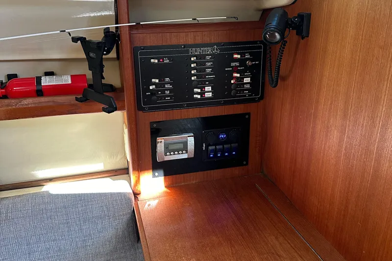 Slide: The Image of Control panel inside a 1992 Hunter 28 sailboat, featuring switches and a fire extinguisher. - 4