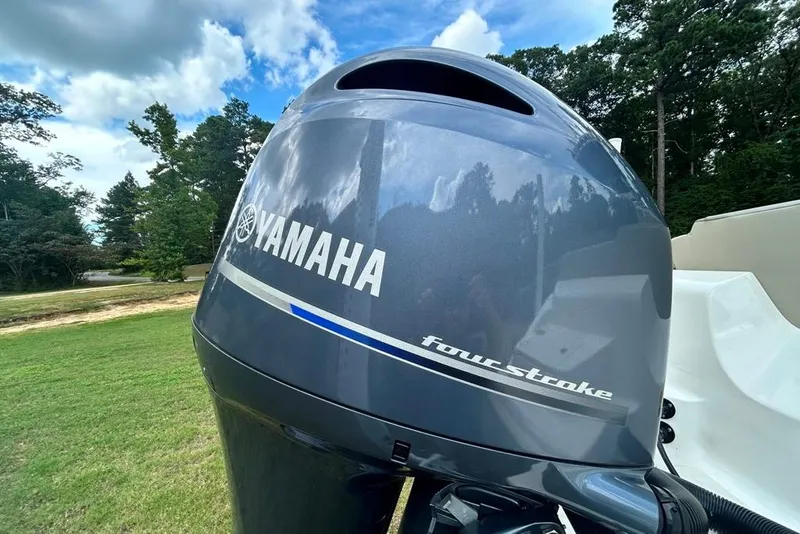 Slide: The Image of Yamaha four-stroke engine on 2022 Key West 219 FS boat, outdoors with trees in background. - 10