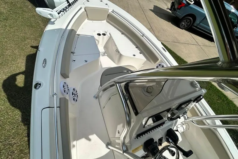 Slide: The Image of 2022 Key West 219 FS boat interior with seating and control console, parked on grass. - 16