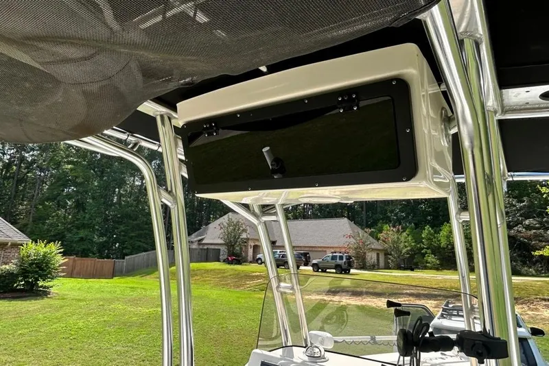 Slide: The Image of 2022 Key West 219 FS boat interior with T-top and console, parked in a residential area. - 35