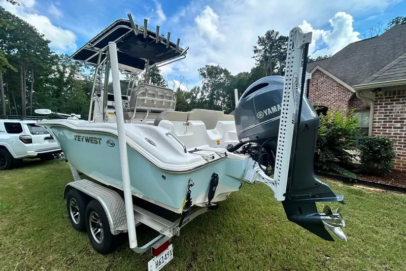 Slide: The Image of 2022 Key West 219 FS boat on trailer, featuring Yamaha engine, parked on grass. - 4