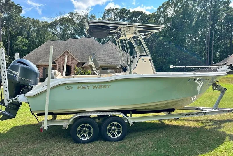 Slide: The Image of 2022 Key West 219 FS boat on trailer, parked on grass, with Yamaha engine. - 45