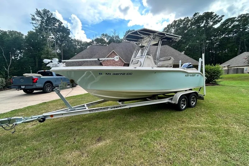 Slide: The Image of 2022 Key West 219 FS boat on trailer, parked on grass near a house. - 6