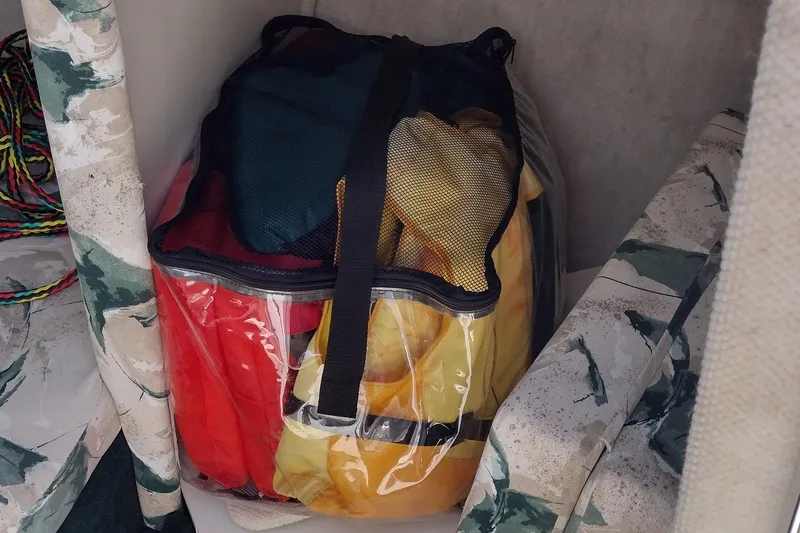 Slide: The Image of Storage area in a 1999 Sea Ray 215 Express Cruiser with colorful life jackets. - 13