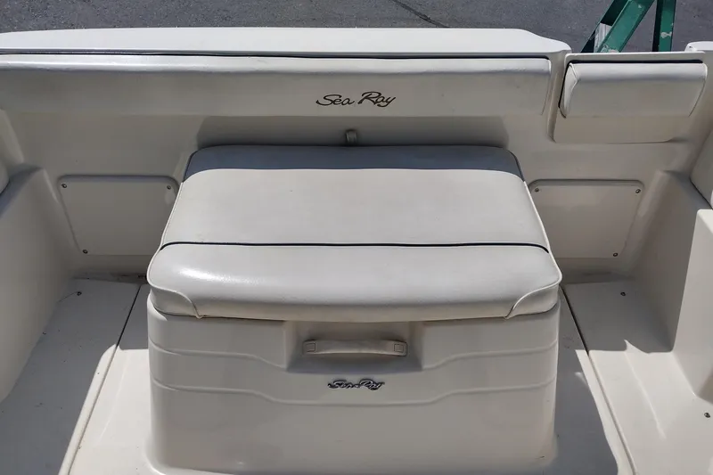 Slide: The Image of 1999 Sea Ray 215 Express Cruiser interior seating with storage compartment. - 16