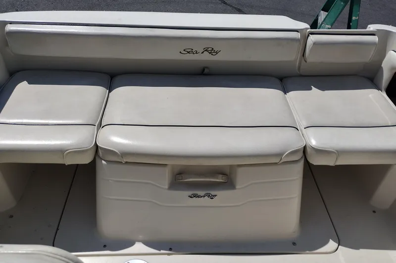 Slide: The Image of 1999 Sea Ray 215 Express Cruiser interior seating, featuring cushioned bench seats. - 20