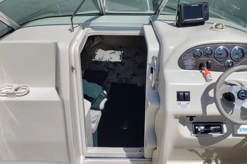 Slide: The Image of 1999 Sea Ray 215 Express Cruiser interior with steering console and cabin entrance. - 21