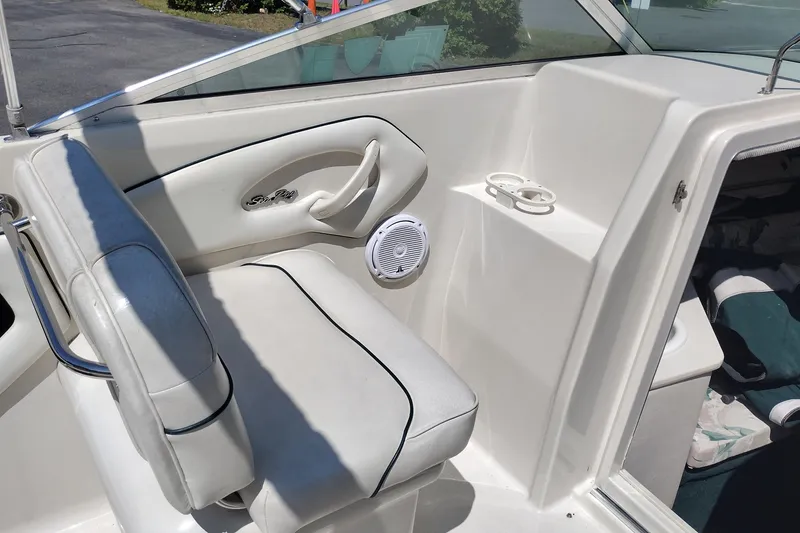 Slide: The Image of 1999 Sea Ray 215 Express Cruiser interior with white seating and cup holders. - 23