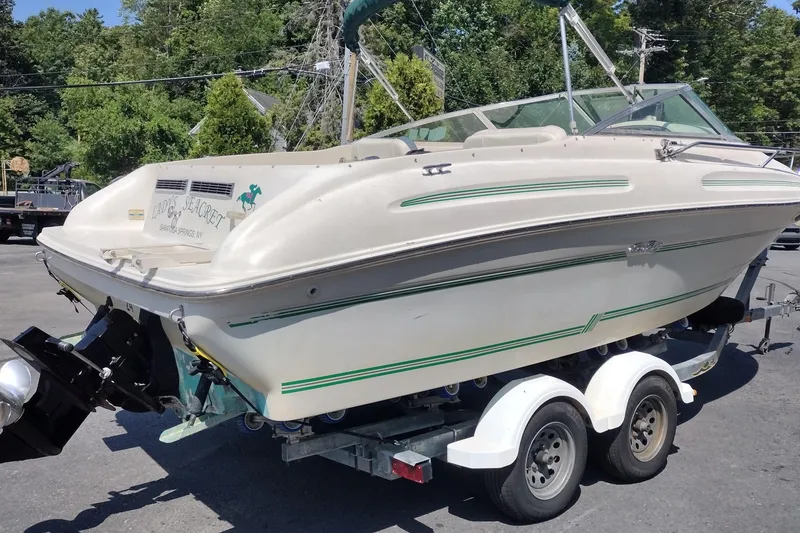 Slide: The Image of 1999 Sea Ray 215 Express Cruiser on trailer, parked outdoors. - 4