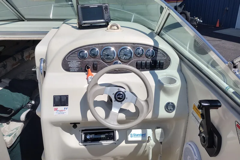 Slide: The Image of 1999 Sea Ray 215 Express Cruiser dashboard with steering wheel and navigation equipment. - 9
