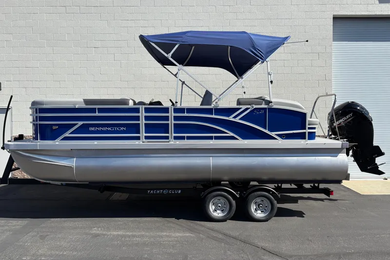 The Image of 2026 Bennington 21 SSB pontoon boat with blue canopy on trailer. - 0
