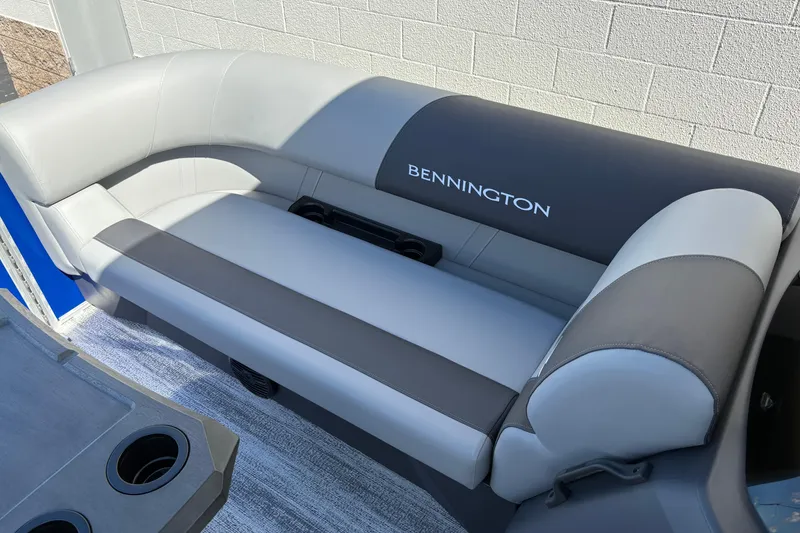 Slide: The Image of 2026 Bennington 21 SSB boat seating with gray upholstery and integrated cup holders. - 11
