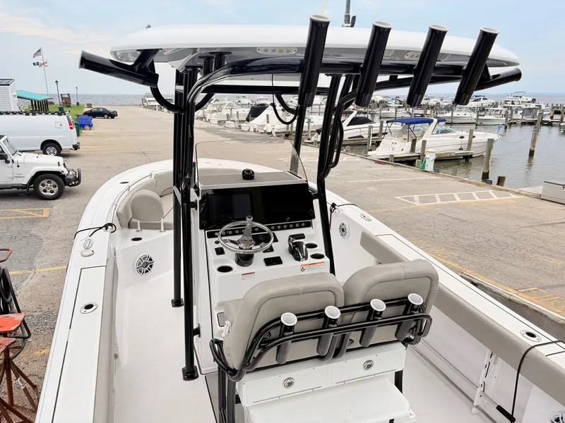 Slide: The Image of 2022 Sportsman 241 Heritage boat at marina, featuring modern helm and seating. - 12