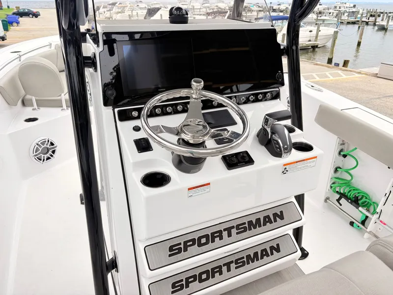 Slide: The Image of 2022 Sportsman 241 Heritage boat console with steering wheel and controls at marina. - 15