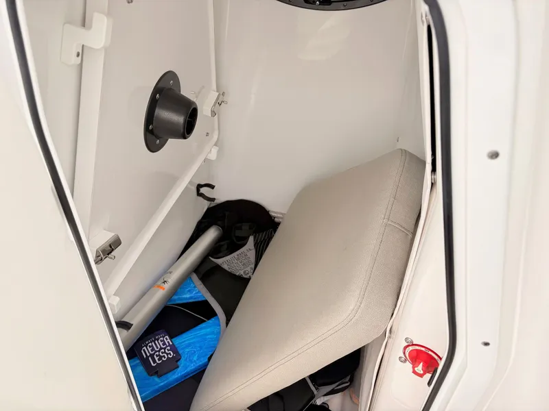 Slide: The Image of Storage compartment in a 2022 Sportsman 241 Heritage boat, featuring seat cushion and equipment. - 27