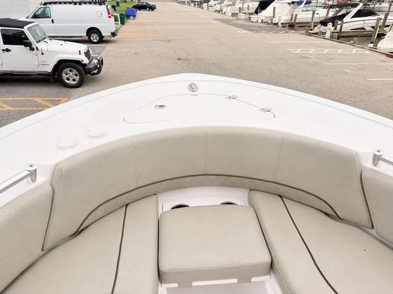 Slide: The Image of 2022 Sportsman 241 Heritage boat interior with beige seating at a marina. - 31