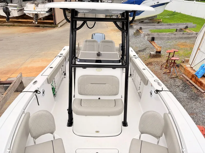 Slide: The Image of 2022 Sportsman 241 Heritage boat interior with seating and console, docked outdoors. - 34