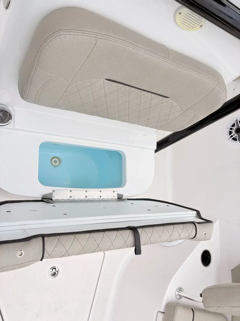 Slide: The Image of 2022 Sportsman 241 Heritage boat interior with cushioned seating and storage compartment. - 36