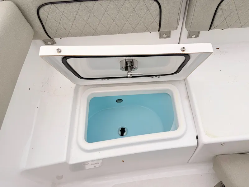 Slide: The Image of Livewell compartment on a 2022 Sportsman 241 Heritage boat, featuring cushioned seating. - 46