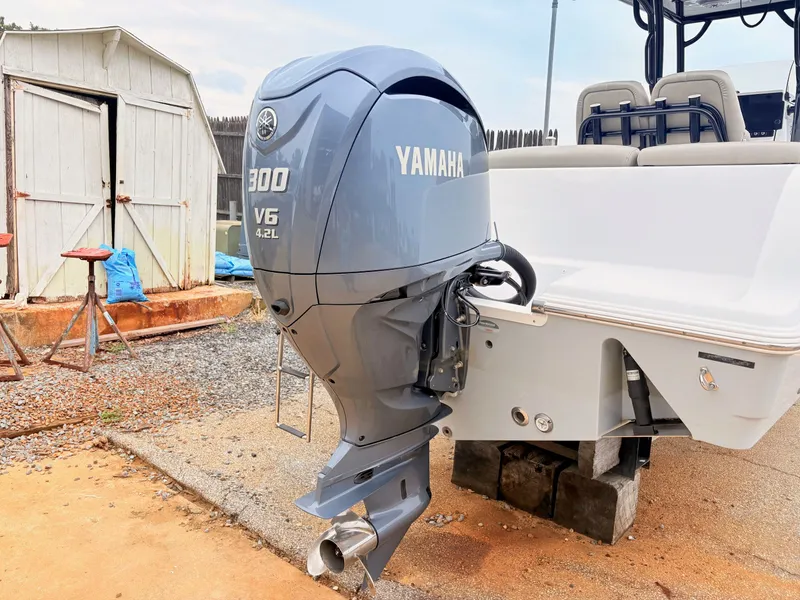 Slide: The Image of 2022 Sportsman 241 Heritage boat with Yamaha 300 V6 4.2L outboard engine, parked near a shed. - 5