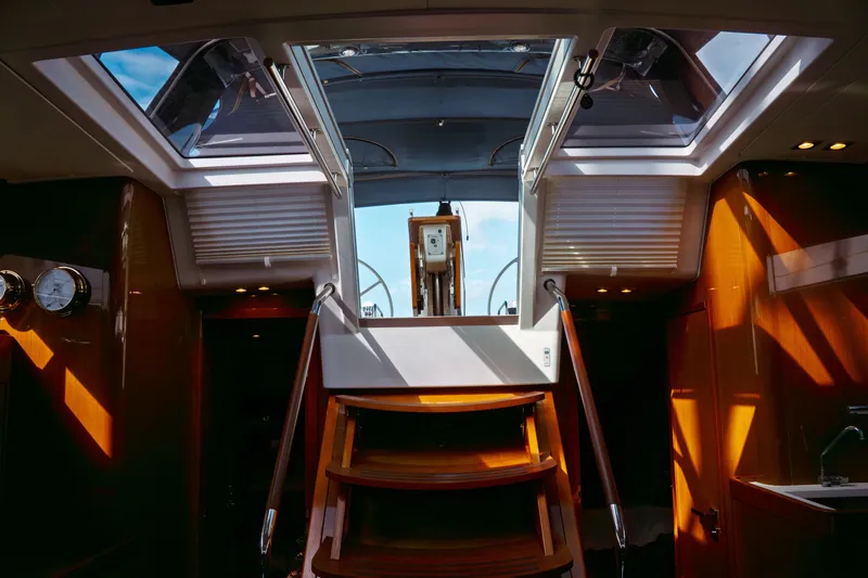 Slide: The Image of Interior view of 2016 Beneteau Oceanis 60 yacht, featuring wooden stairs and skylights. - 16