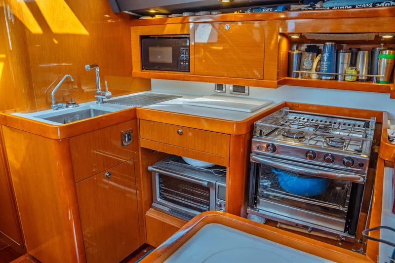 Slide: The Image of Luxurious kitchen in 2016 Beneteau Oceanis 60 yacht with modern appliances and wooden cabinetry. - 25