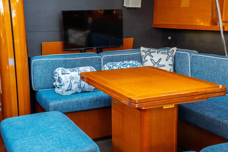 Slide: The Image of Luxurious interior of 2016 Beneteau Oceanis 60 yacht with blue seating and wooden table. - 26