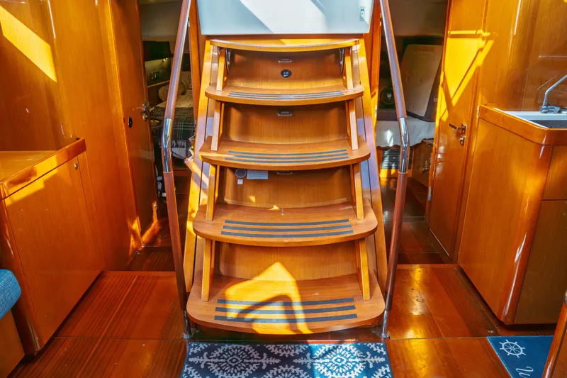 Slide: The Image of Interior of 2016 Beneteau Oceanis 60 yacht with wooden stairs and cabinetry. - 32