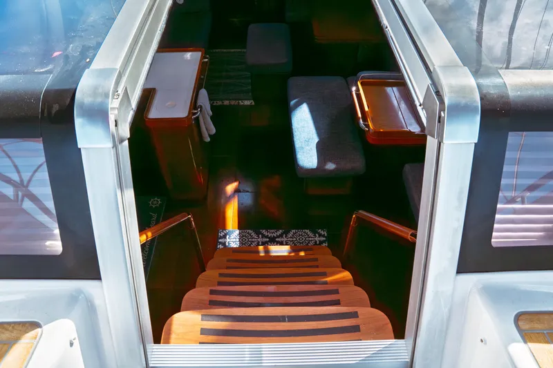 Slide: The Image of Interior view of 2016 Beneteau Oceanis 60 yacht, showcasing elegant wooden stairs and seating area. - 34