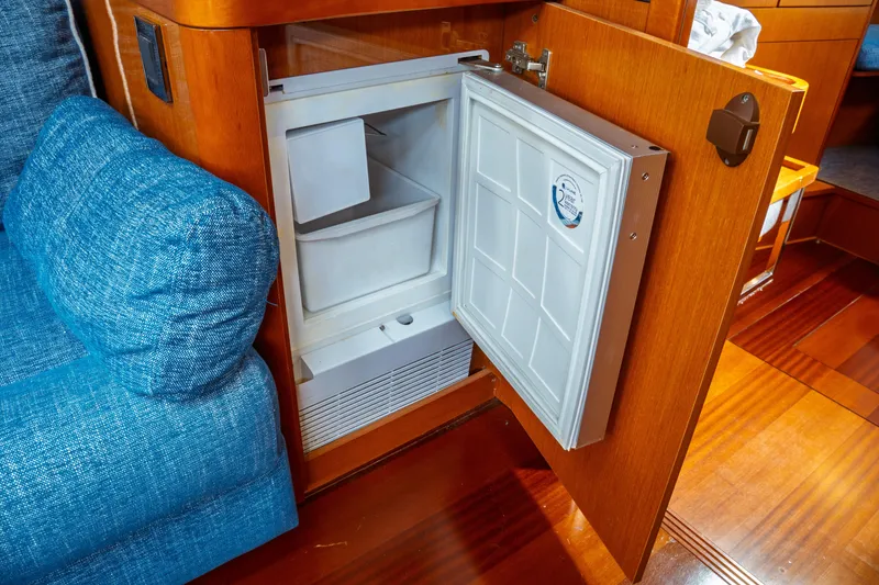 Slide: The Image of Open refrigerator in 2016 Beneteau Oceanis 60 yacht interior, with blue upholstery and wooden finish. - 4