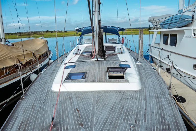 Slide: The Image of 2016 Beneteau Oceanis 60 sailboat docked, showcasing spacious deck and sleek design. - 49