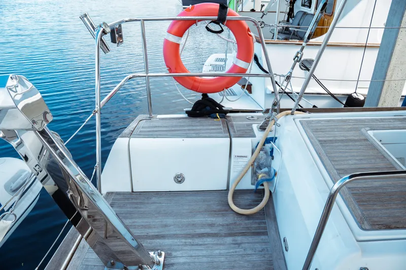 Slide: The Image of 2016 Beneteau Oceanis 60 yacht deck with lifebuoy and wooden flooring. - 51