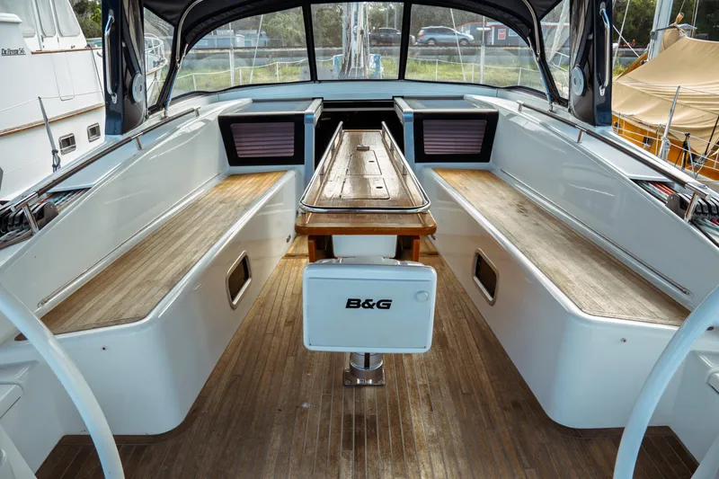 Slide: The Image of Spacious cockpit of 2016 Beneteau Oceanis 60 sailboat with wooden seating and table. - 55
