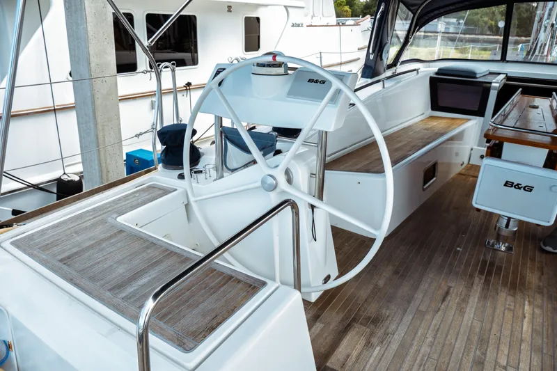 Slide: The Image of 2016 Beneteau Oceanis 60 yacht cockpit with steering wheel and wooden deck. - 70