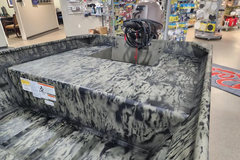 Slide: The Image of 2026 Tracker 1542 LW boat with camouflage design in a showroom setting. - 5