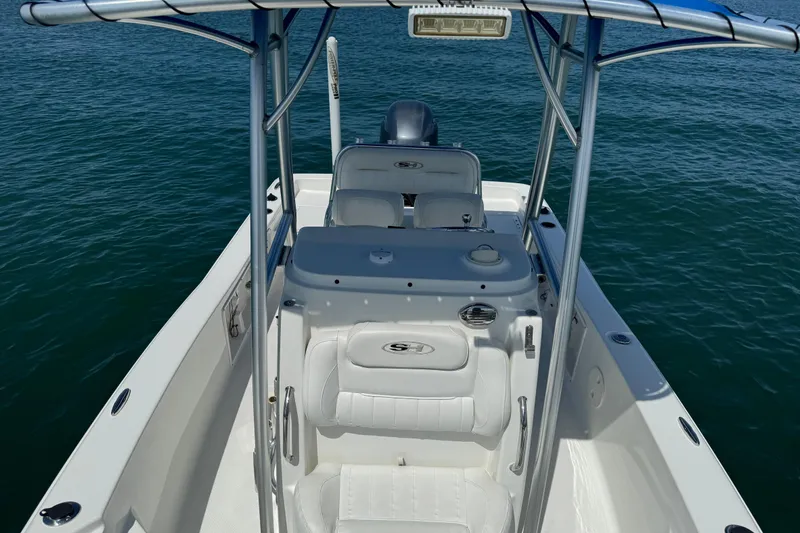 Slide: The Image of 2016 Sea Hunt BX 20 BR boat interior with white seating on calm water. - 17