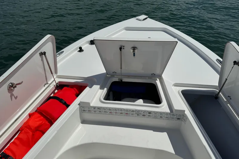 Slide: The Image of 2016 Sea Hunt BX 20 BR boat with open storage compartments on calm water. - 22