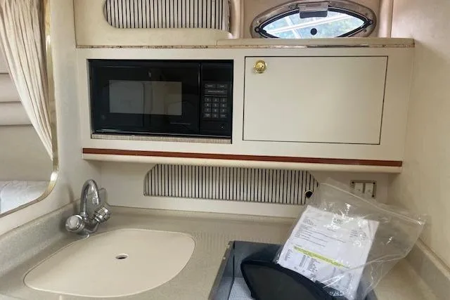 Slide: The Image of Interior of 2000 Sea Ray 270 Sundancer with sink, microwave, and storage cabinet. - 11