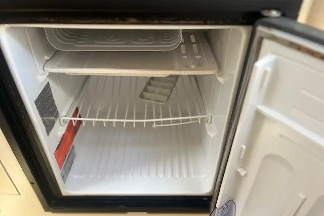 Slide: The Image of Empty mini fridge inside a 2000 Sea Ray 270 Sundancer boat. - 13
